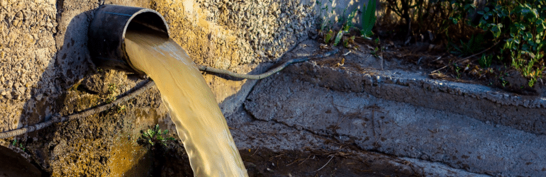 Wastewater sewage pipe dumps the dirty contaminated water into the river