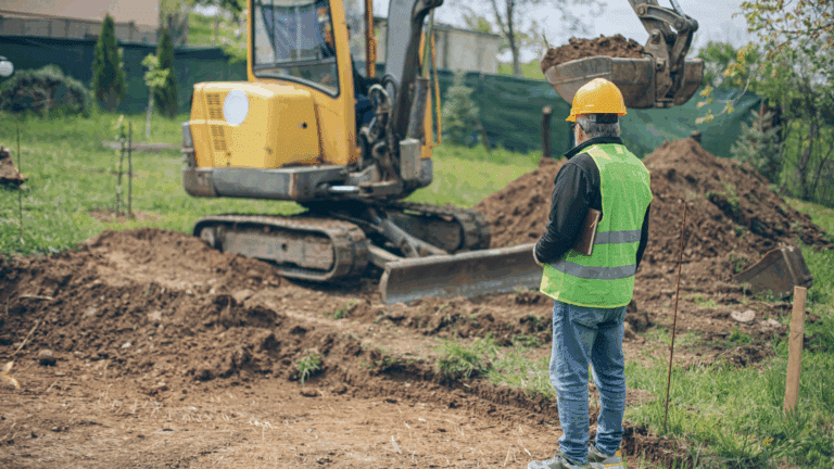 A reliable excavating contractor looking and coordinating an excavation process in homeowners backyard