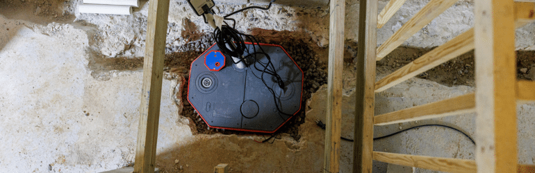 Sump pump installation in basement stairwell